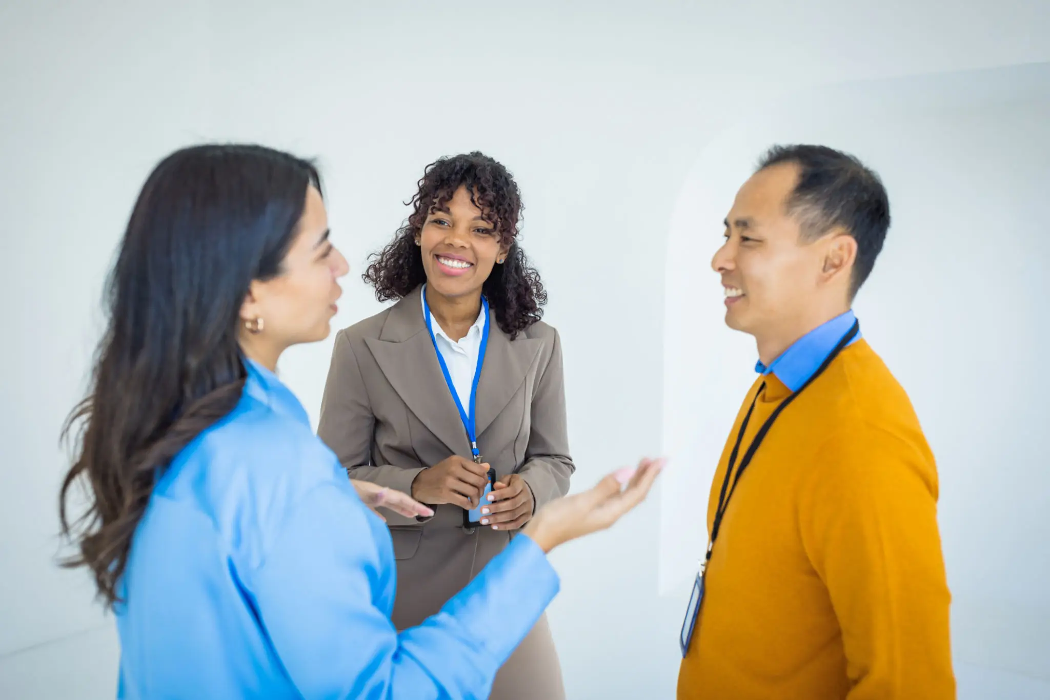 Three professionals engaged in a lively conversation in an office.
