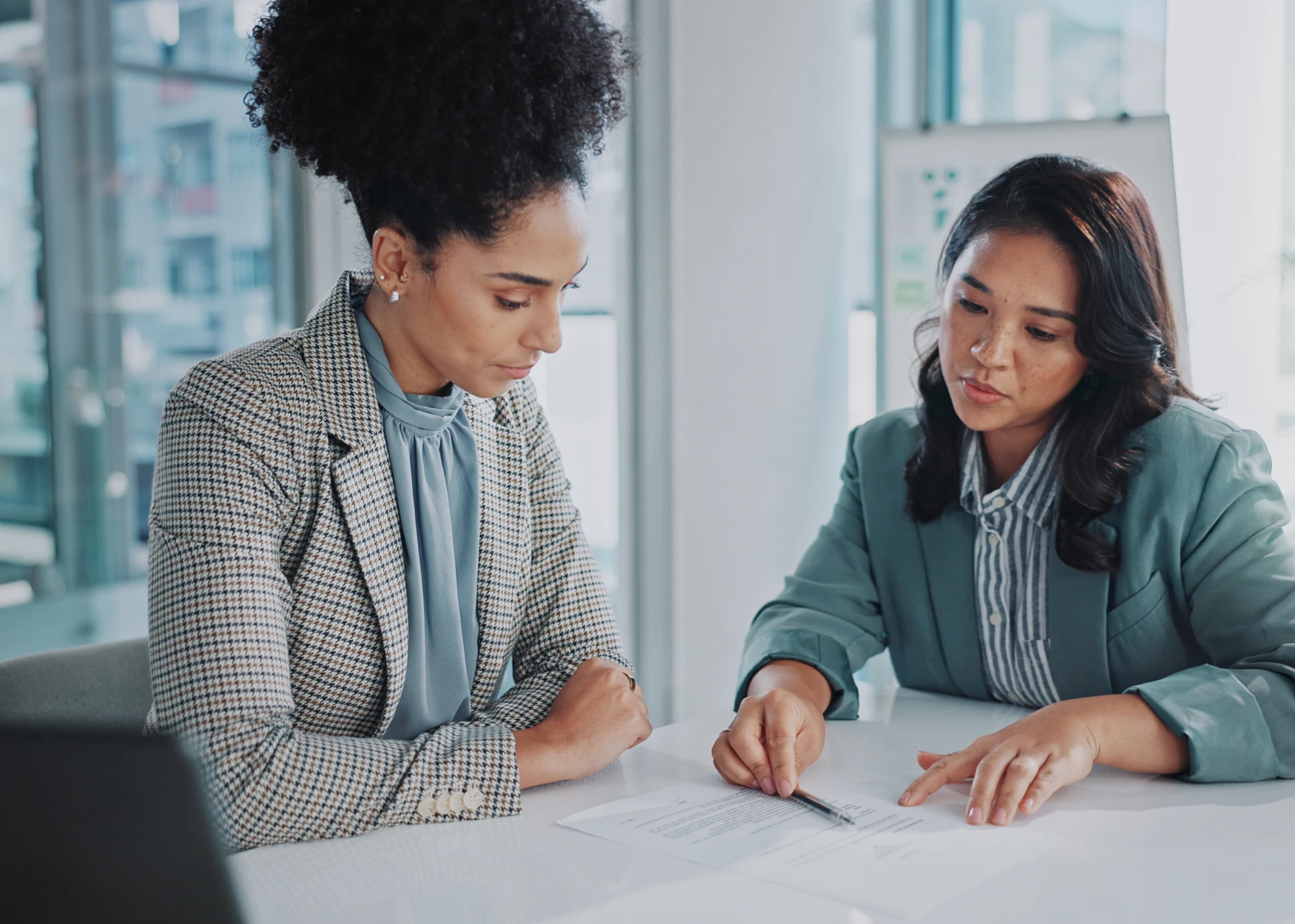 Two women reviewing documents in office